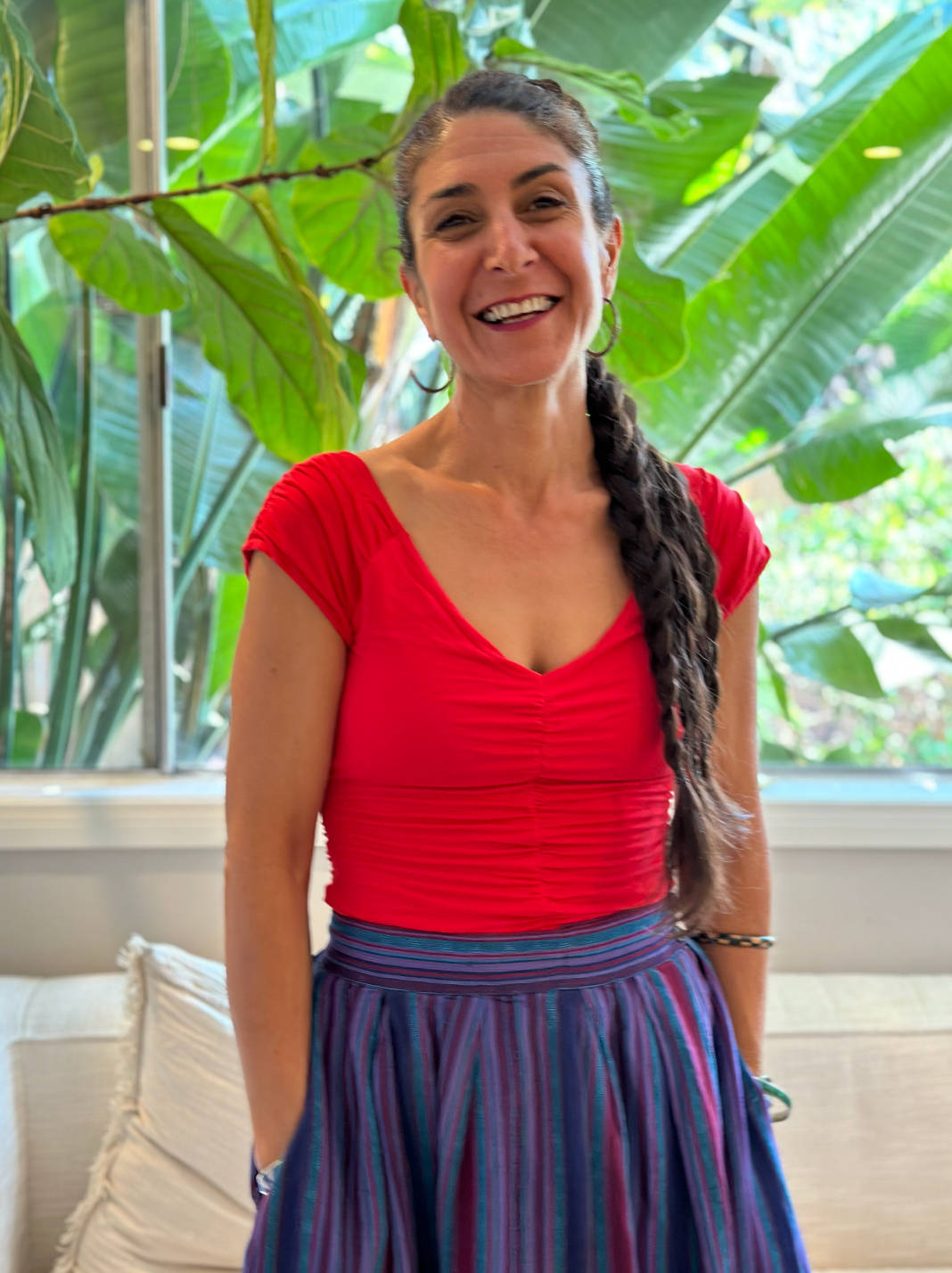 image of hedieh shariatmadari, energy healing practitioner at your vitality elevated and herbalist at honeypaw love herbals standing in front of a garden background smiling 